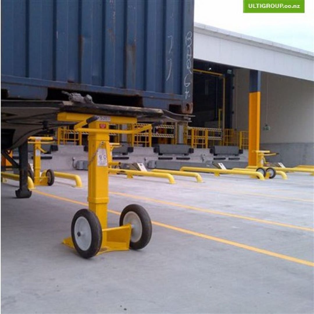 Yellow mobile trailer stand supporting the front of a blue shipping container.
