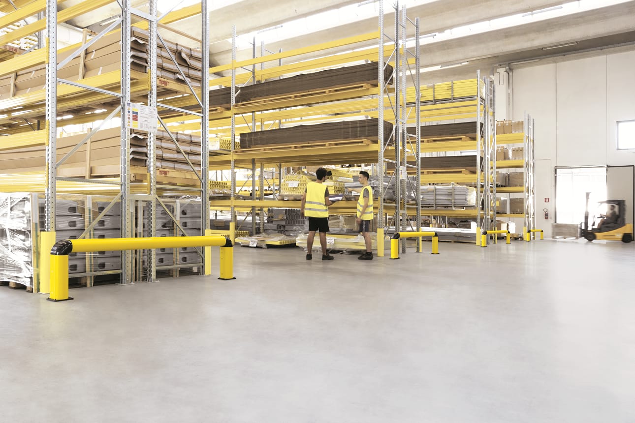 Yellow industrial safety barriers protecting warehouse racking systems.