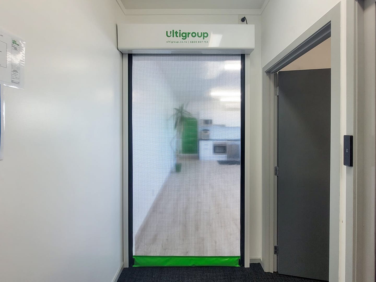 Ulti Group mesh roll-up door installed in an office hallway.