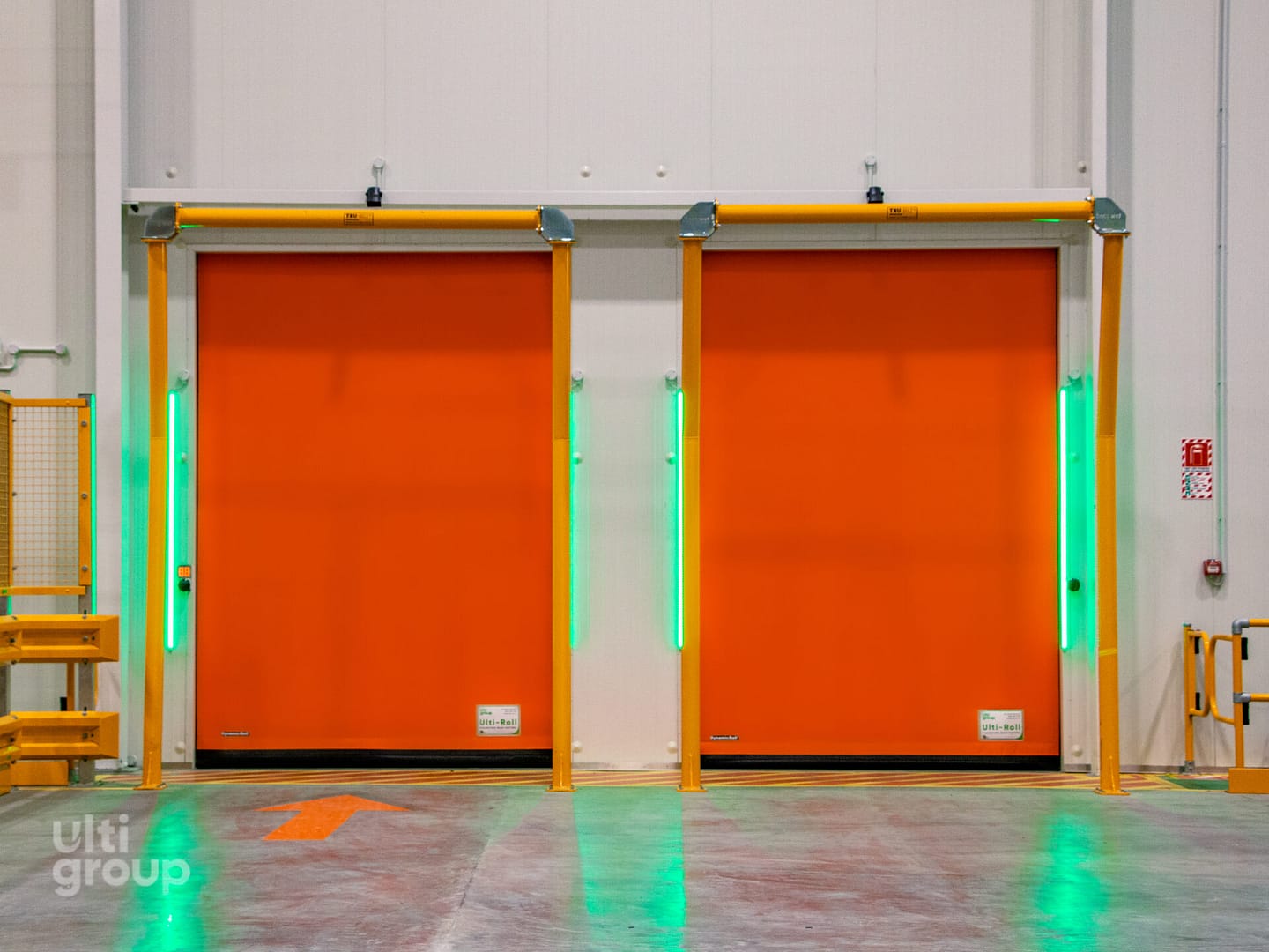 Two orange Ulti-Roll high speed doors with green LED safety lights.
