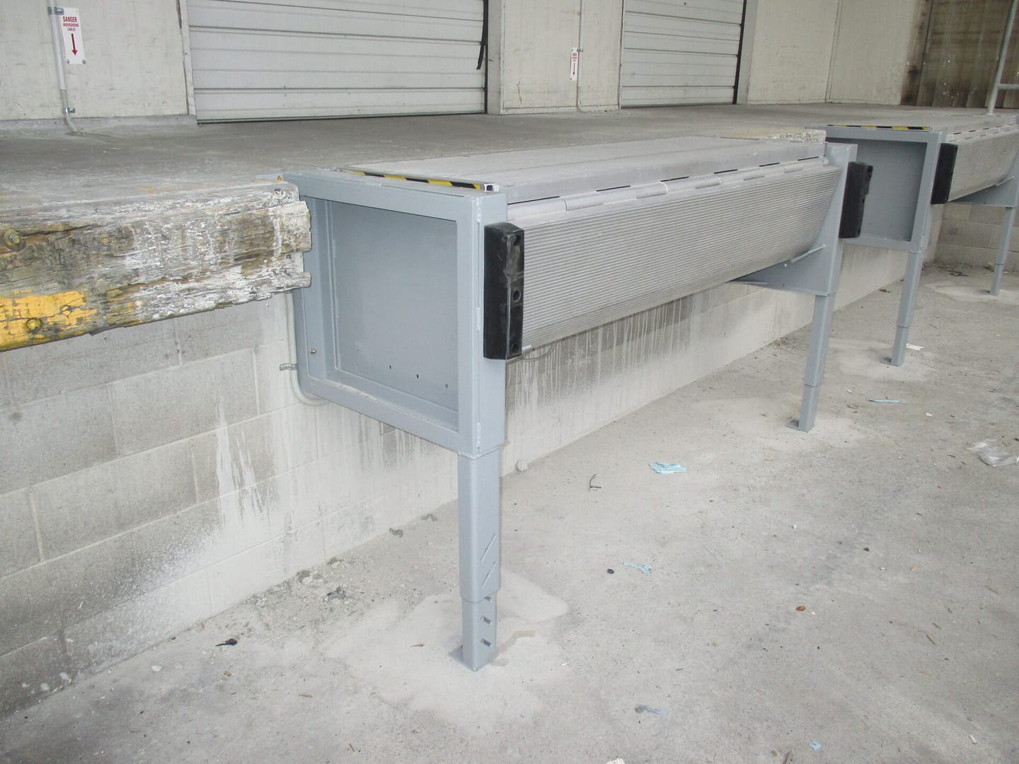 Aluminium mini dock leveller installed on a concrete loading bay.