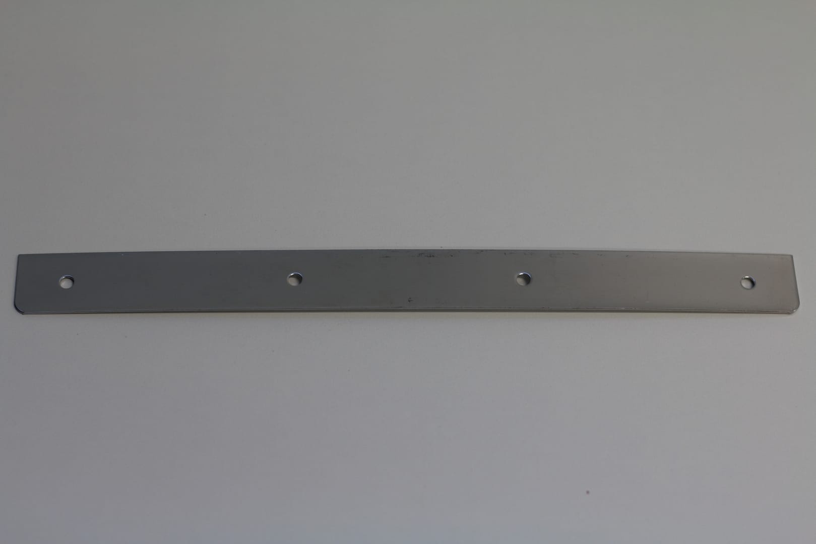 A long, flat stainless steel mounting strip with four pre-drilled holes.