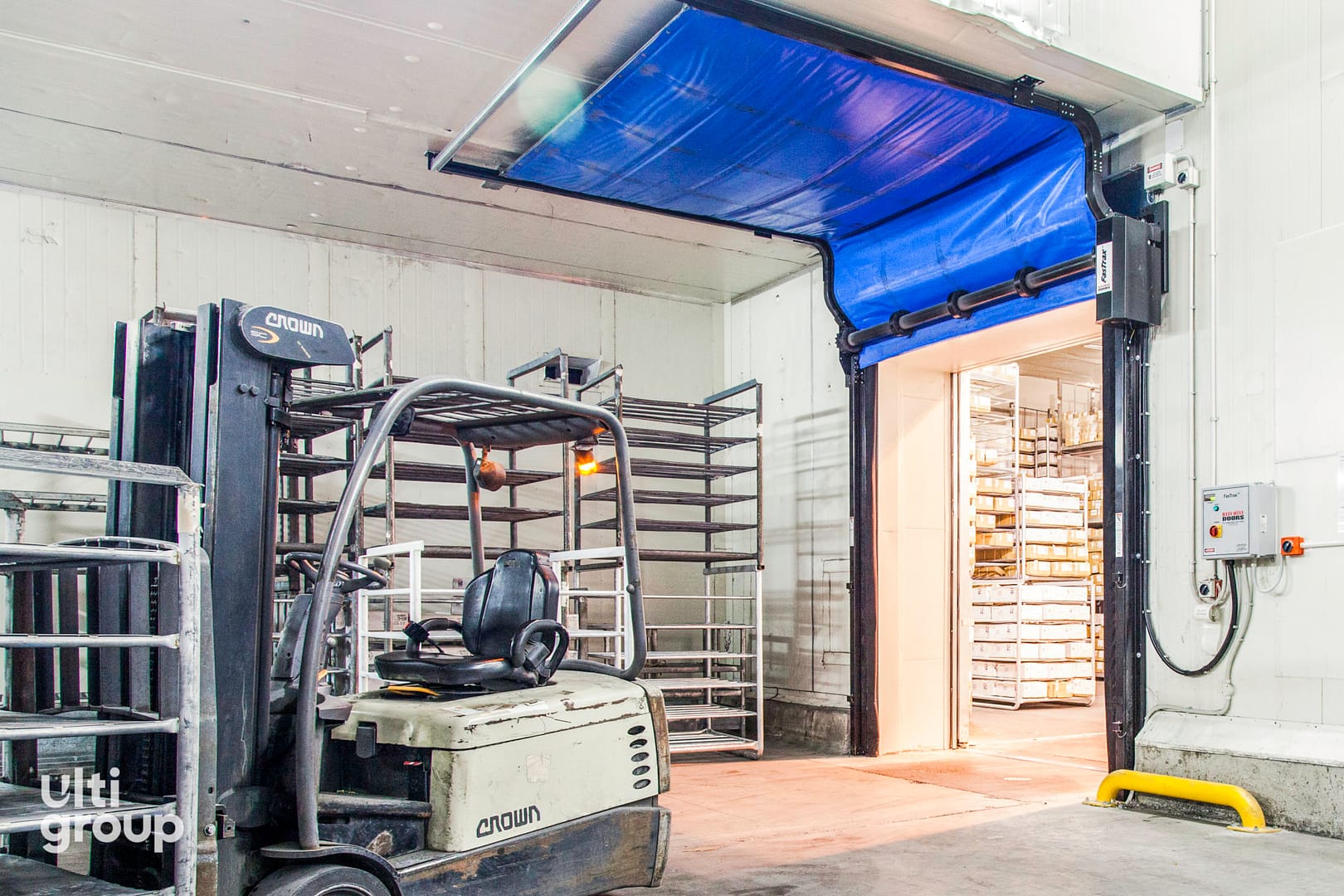 A blue Fastrax FR Door installed at a cold storage facility entrance.