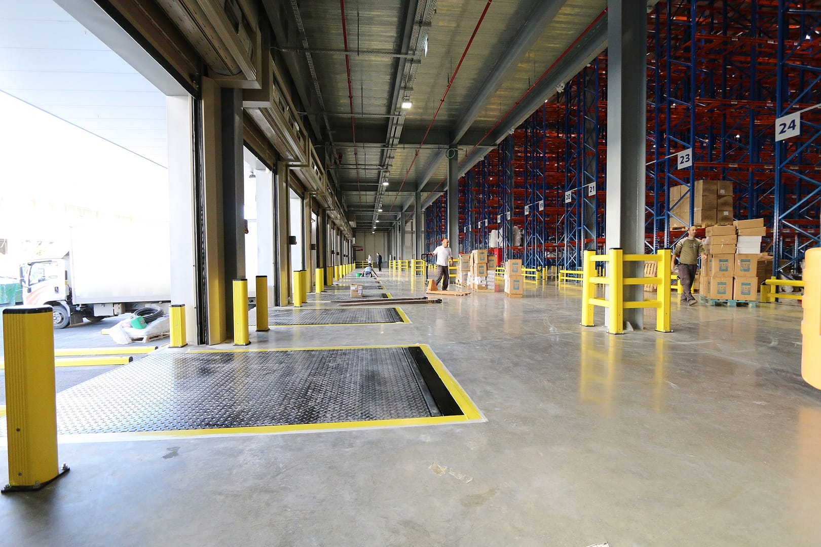 Vertical Storing Dock Levellers and safety bollards at a loading bay.