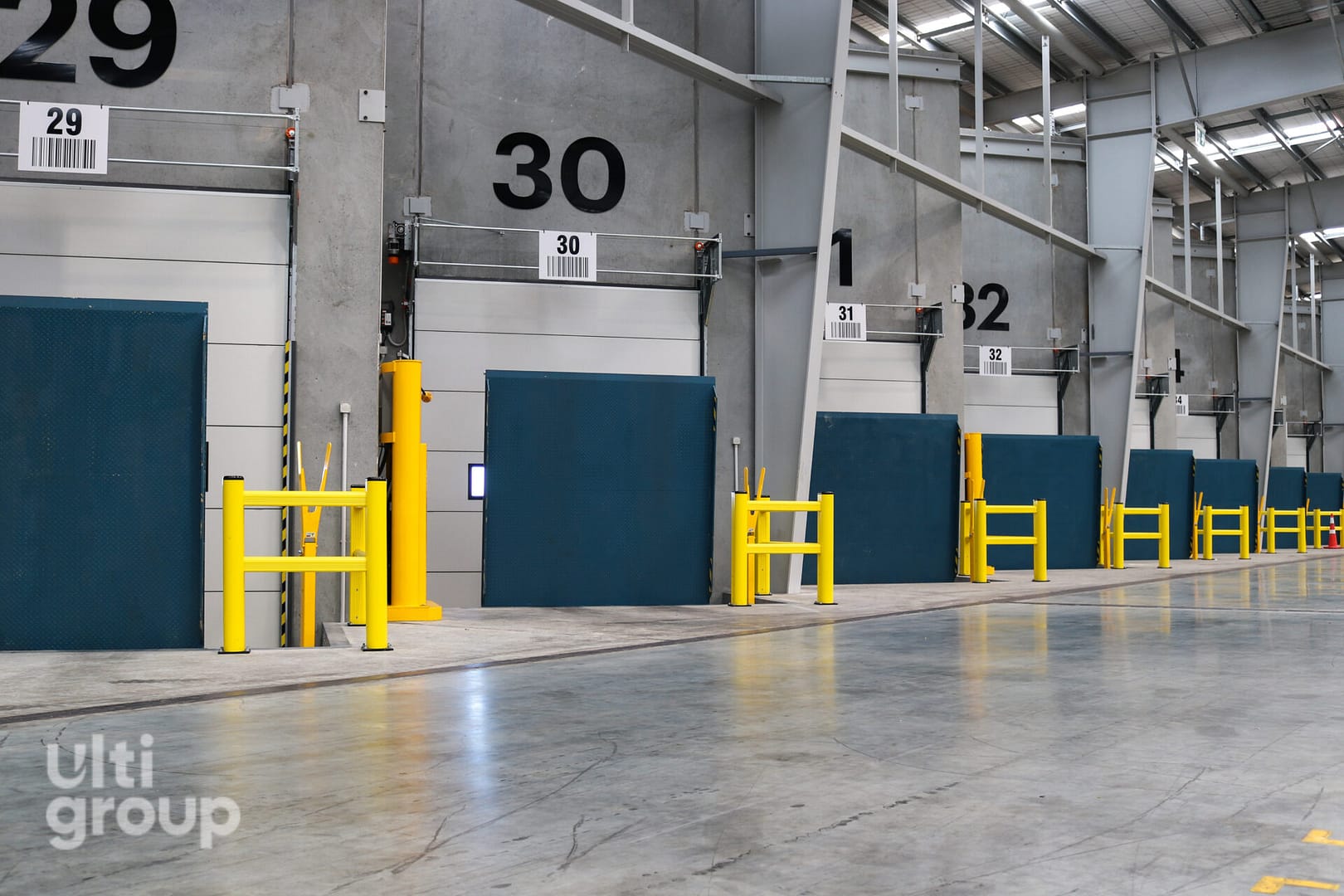 Vertical Storing Dock Levellers and yellow safety barriers at a loading dock facility.