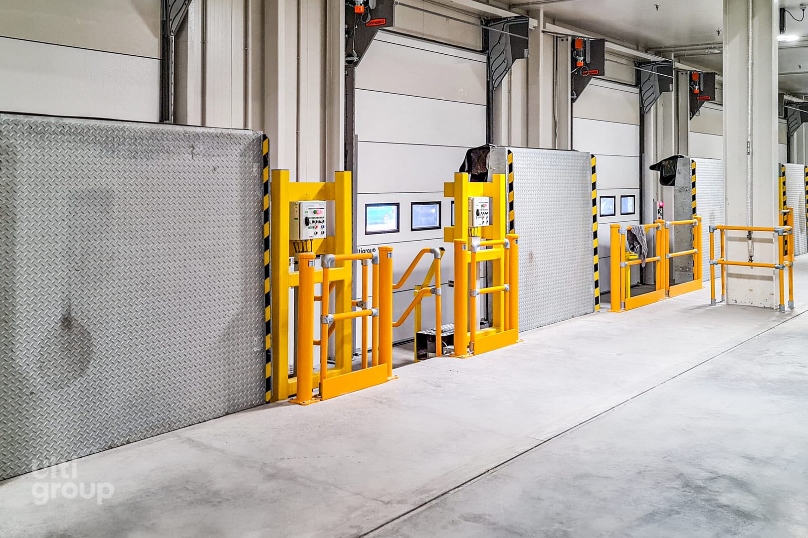 Vertical Storing Dock Levellers and safety barriers in a warehouse.