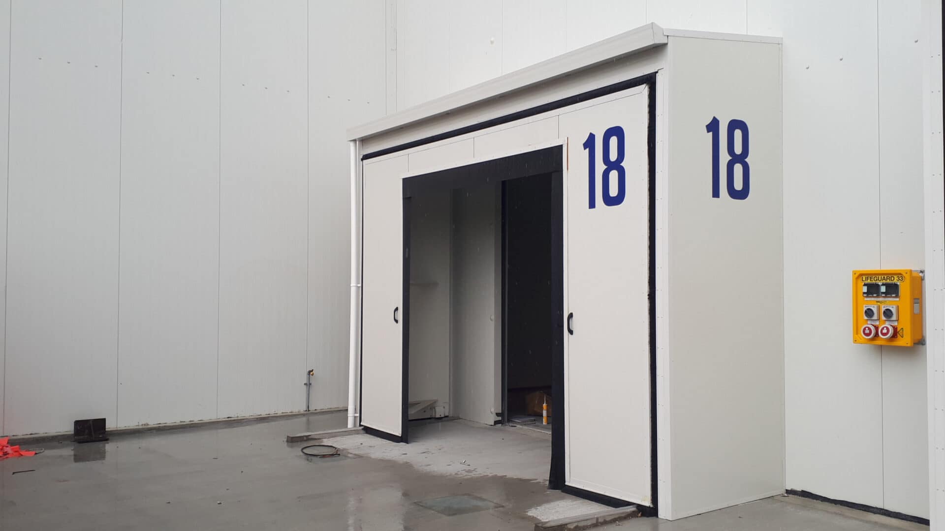 Expandable container shelter with sliding doors and number 18 branding.