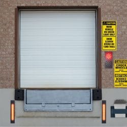 Vertical Storing Dock Leveller and sectional door at a loading bay.