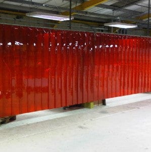 Red translucent PVC strip welding screen in an industrial workshop.