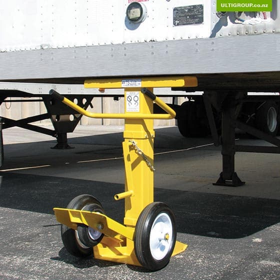 Yellow heavy-duty trailer stand supporting the front of a semi-trailer.
