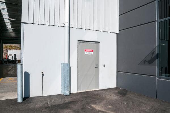 Industrial personnel access door with staff only signage and security keypad.