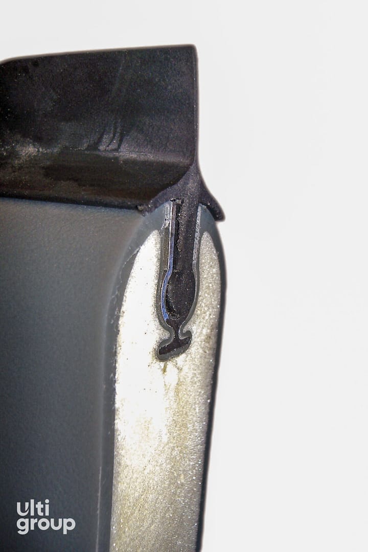 Cross-section of an insulated door panel with a black rubber seal.