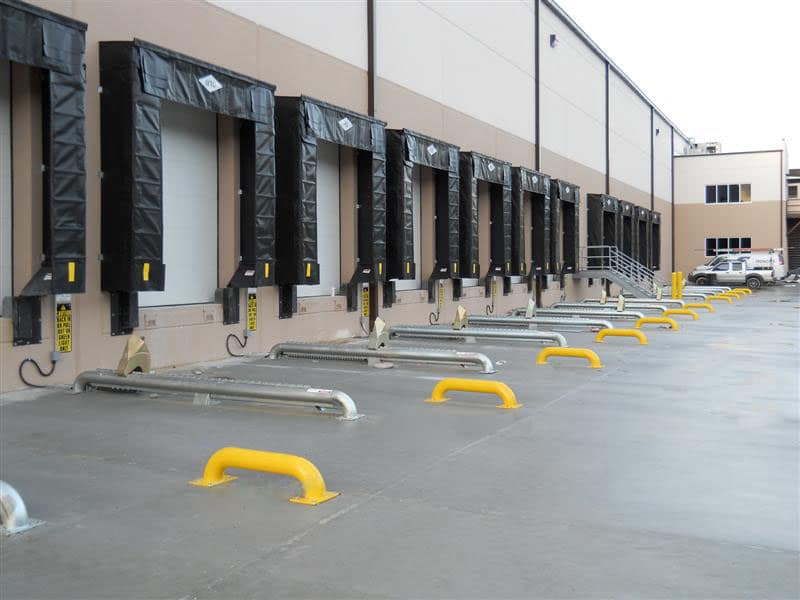 Manual wheel locks and dock seals at a warehouse loading bay.