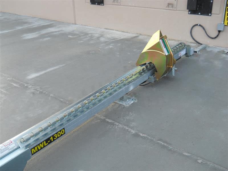 Manual wheel lock system installed on a concrete loading dock floor.