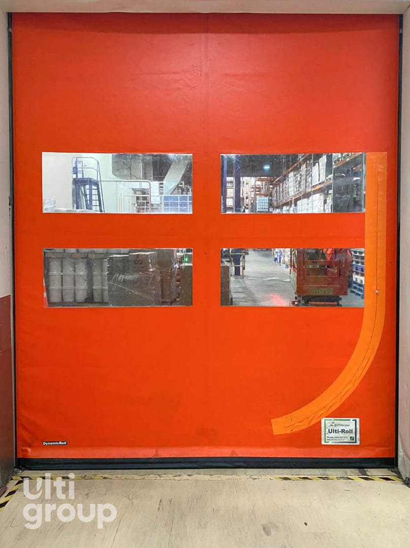 Orange high speed industrial door with four clear vision panels.