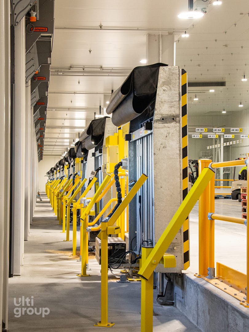 Row of Vertical Storing Dock Levellers in a warehouse facility.