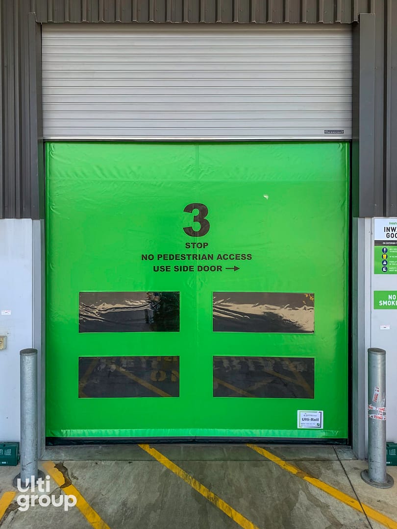 Green Ulti Komby Door with safety signage and vision panels.