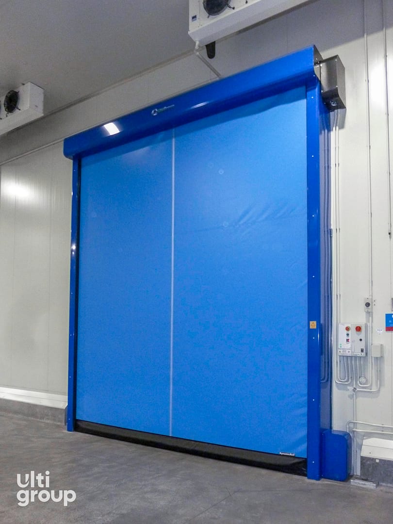 Blue high-speed industrial fabric door installed in a cold storage facility.