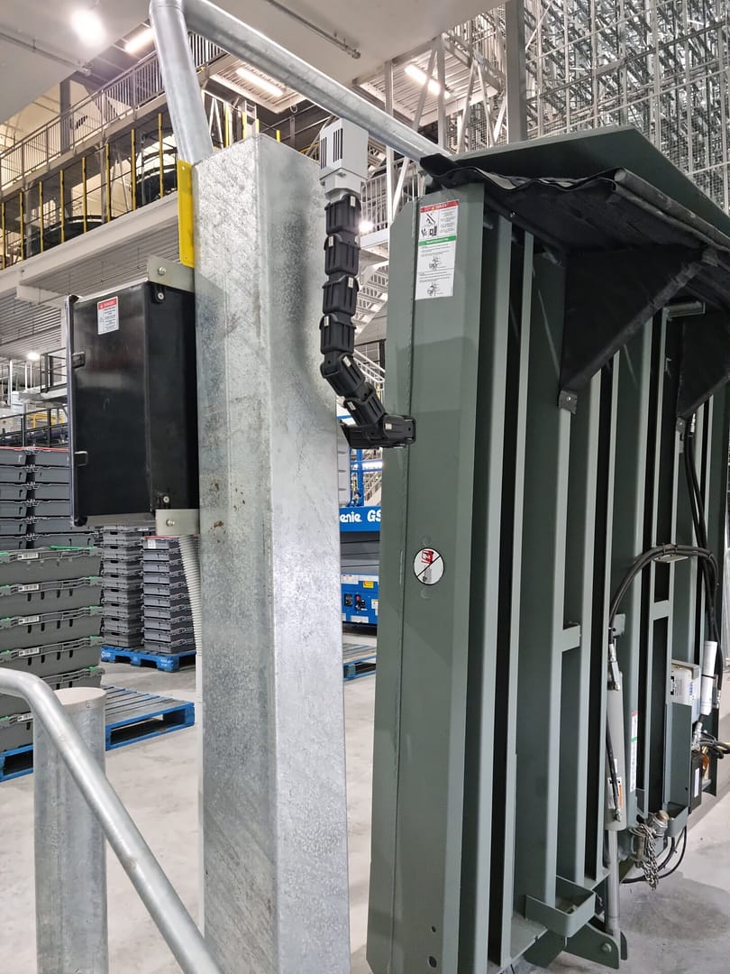 Vertical storing dock leveller with flex neck light in a warehouse.