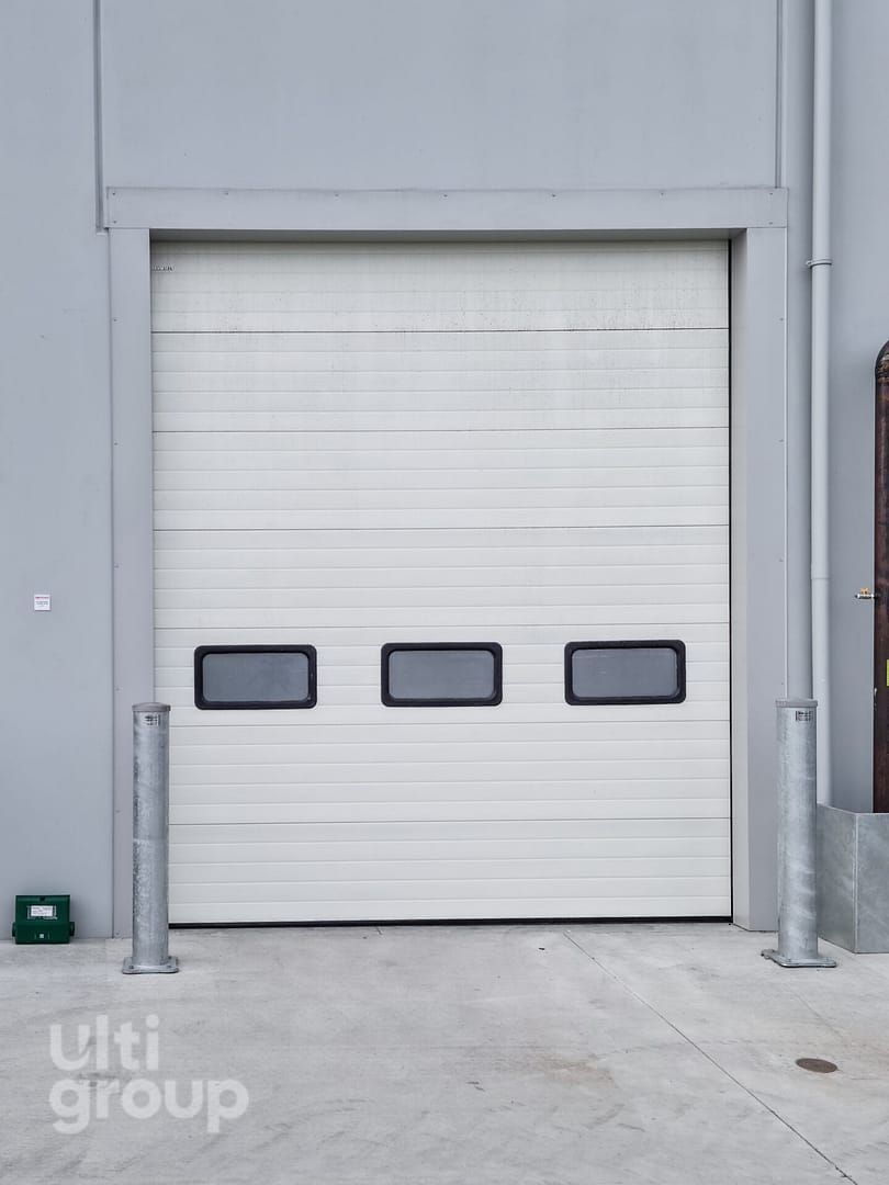 White sectional overhead door with three rectangular vision panels.