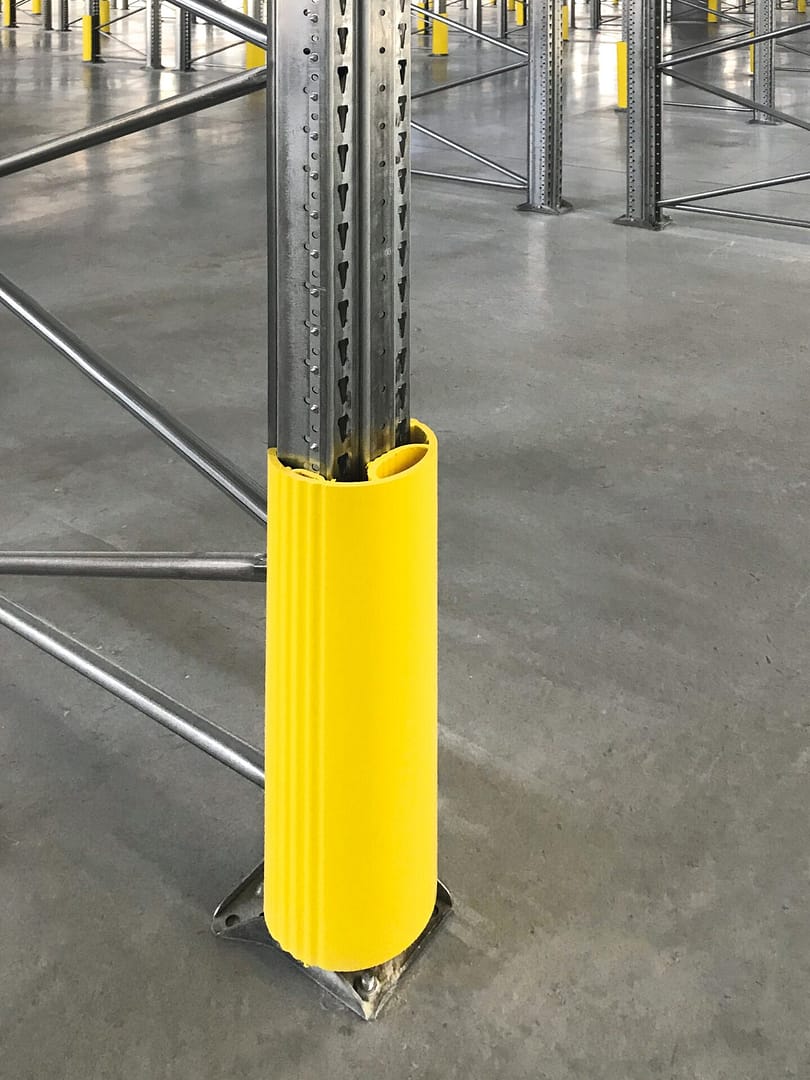 Yellow plastic rack protector installed on a warehouse upright post.