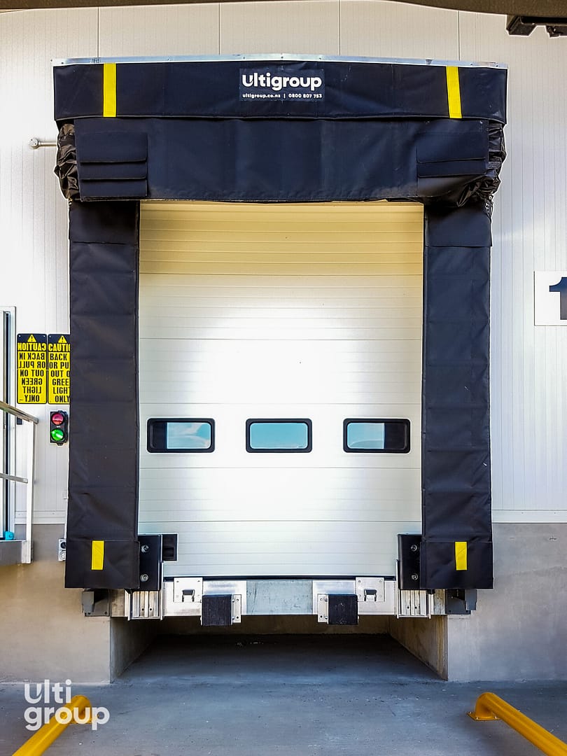 A complete dock loading system with a sectional door and black dock seal.