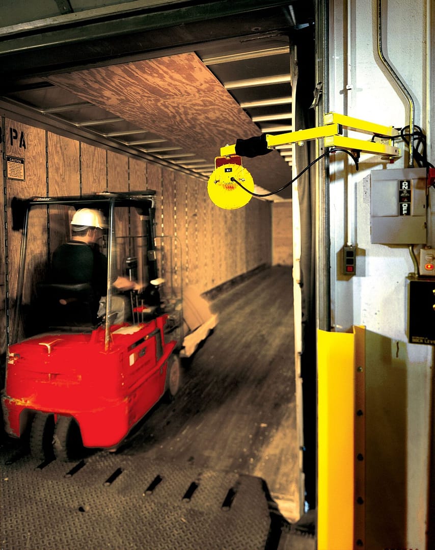 Yellow dock light illuminating the interior of a truck trailer during loading.