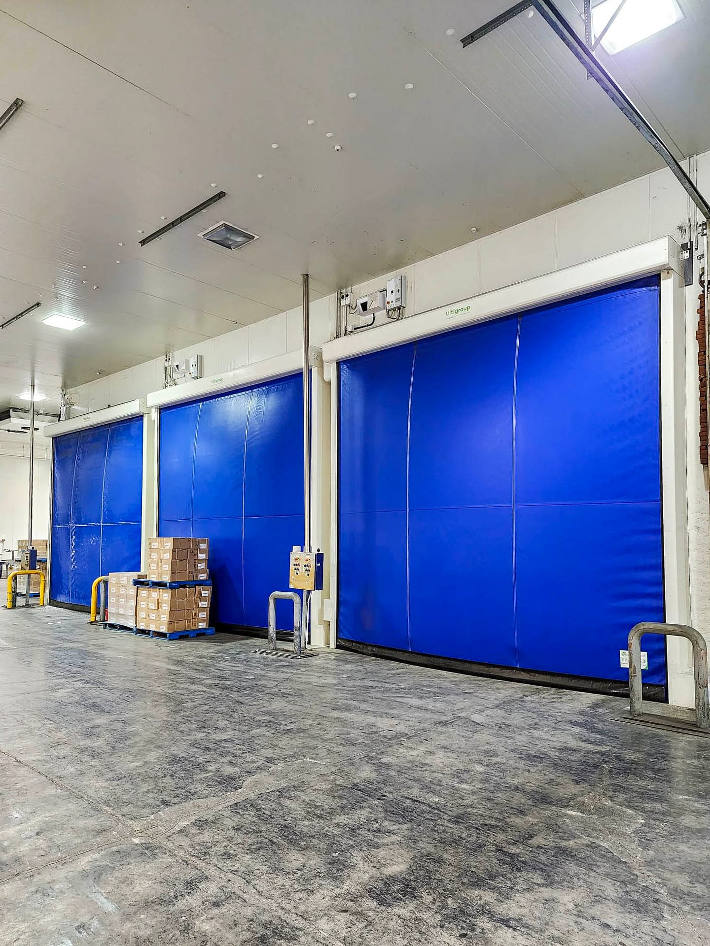 Three blue Ulti Fold Doors installed in a cold storage facility.