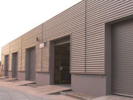 Row of industrial roller doors on a corrugated metal warehouse facade.