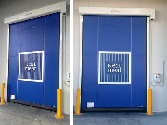 Blue high speed industrial door with Neat Meat branding and yellow bollards.