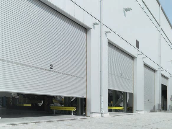 Large grey industrial roller doors installed on a warehouse exterior.