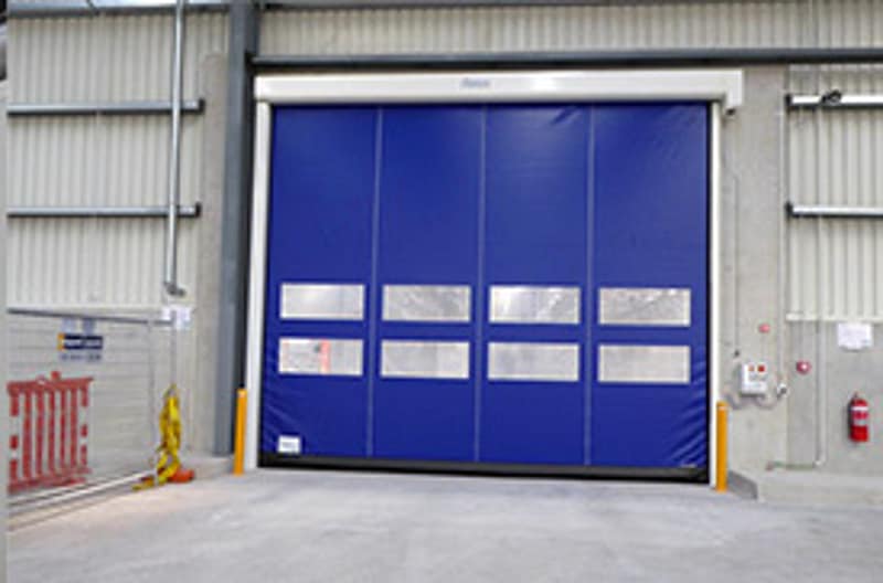 Blue Ulti Fold Door installed in a concrete warehouse opening