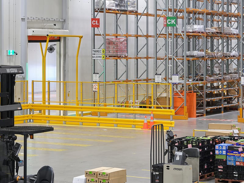 Yellow safety barriers and pallet racking in a distribution centre.