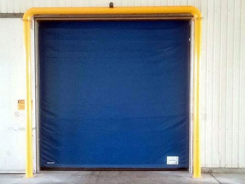 Blue high speed fabric door with yellow protective bollard frame