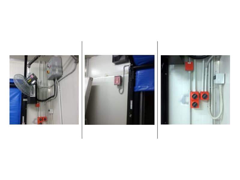 Industrial door control panels, electrical conduit, and wall-mounted fan.