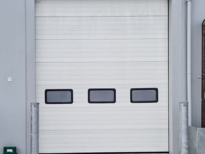 White sectional overhead door with three rectangular vision panels.