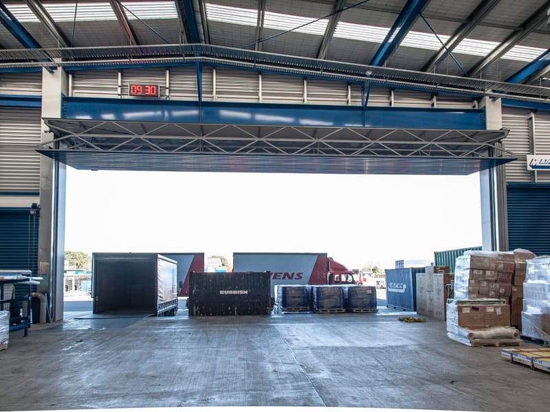 Large Ulti Fold Door open at a busy logistics warehouse loading bay.