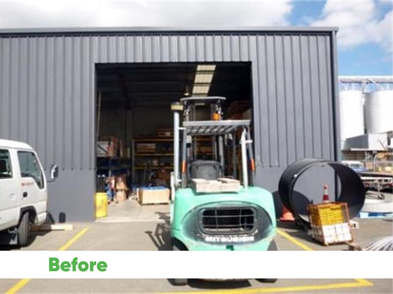 Open warehouse entrance with a green Mitsubishi forklift parked in front.