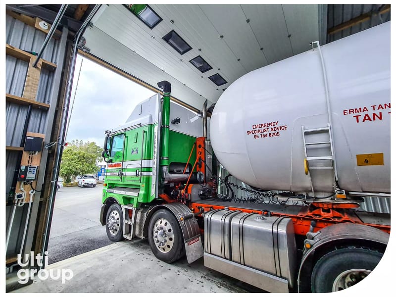 Green Uhlenberg Haulage truck parked under a large sectional industrial door.
